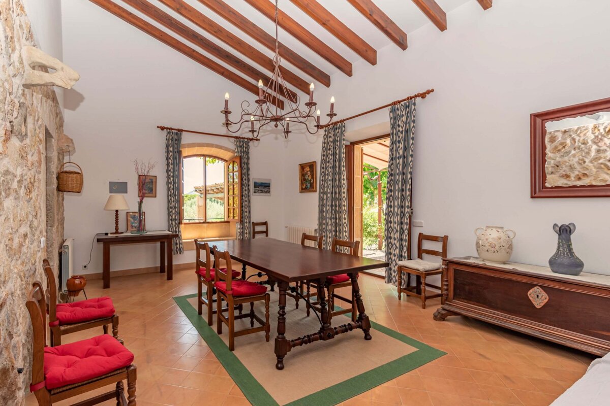 A dining room with a table and chairs and a chandelier
