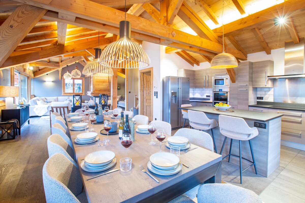 A dining room table with a bottle of wine on it
