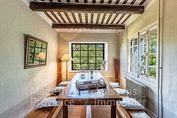 A dining room with a table and benches and the words made in provence on the wall
