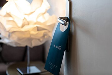 A door hanger that says sweet inn on it