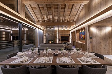 A dining room table with a bottle of wine on it