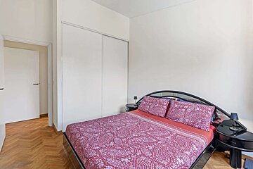 A bedroom with a large bed and a closet