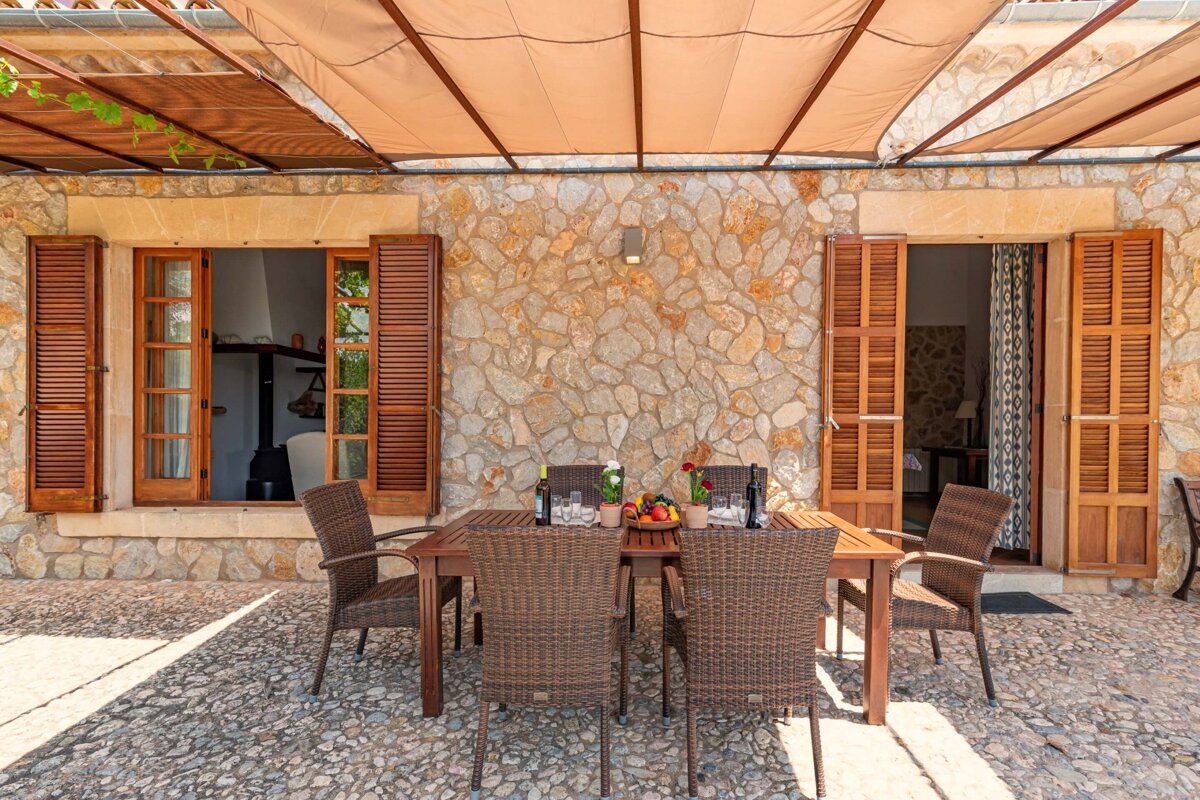 A patio with a table and chairs under an awning