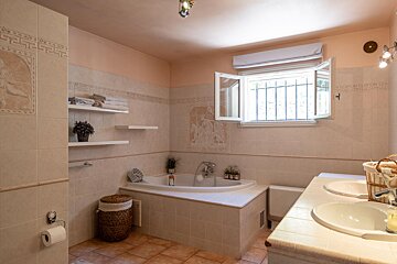 A bathroom with a bathtub and two sinks
