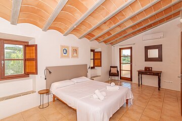 A bedroom with a large bed and a mirror