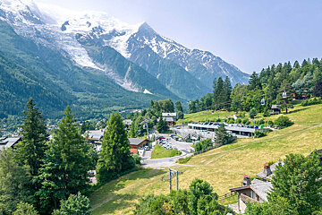 A row of houses sit on a hillside in the woods