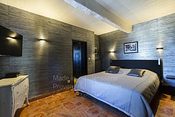 A bedroom with a bed and a dresser that says made in provence