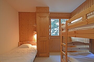 A bedroom with two bunk beds and a window