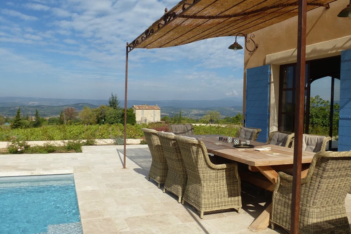 A patio with a table and chairs under a canopy
