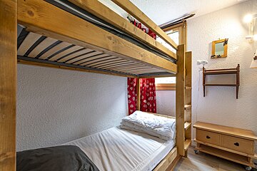 A bunk bed with a single bed underneath it
