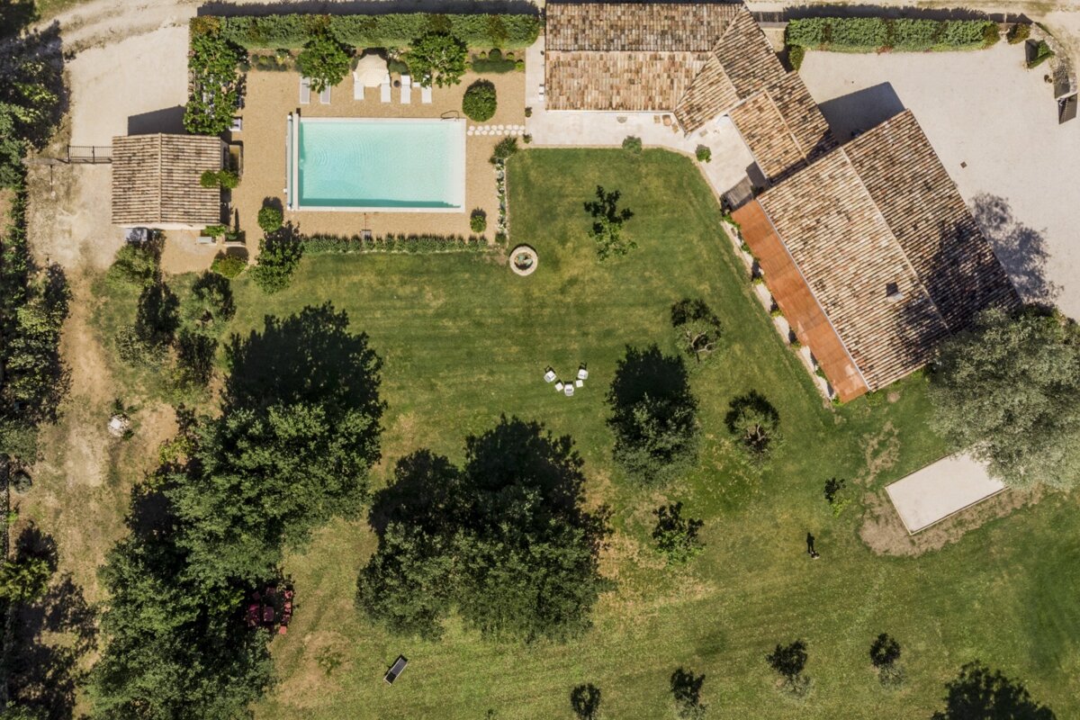 An aerial view of a house with a large pool