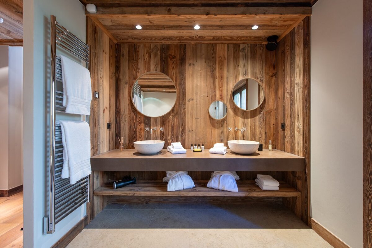 A bathroom with two sinks and two round mirrors
