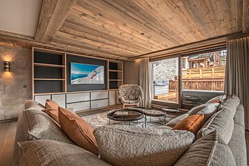 A living room with a large flat screen tv on the wall