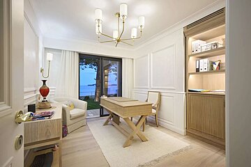 A room with a desk and chairs and a chandelier