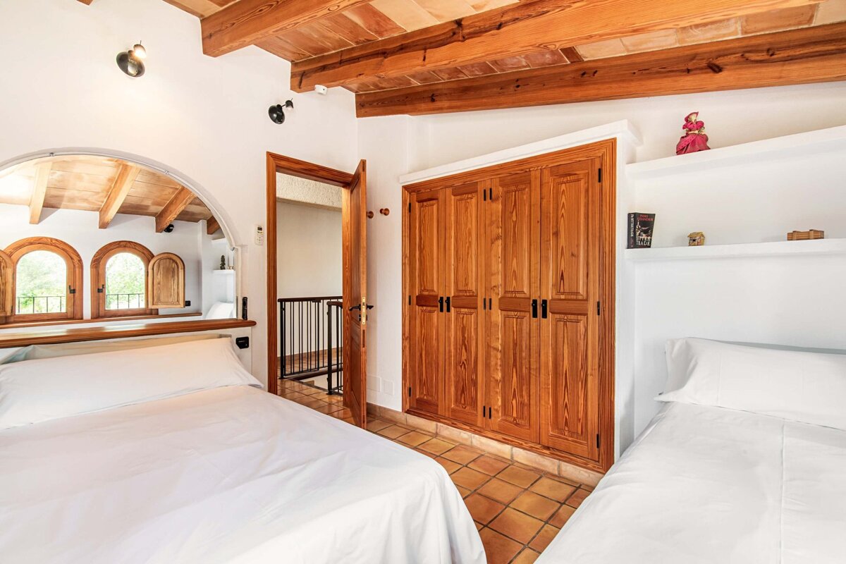 A bedroom with two beds and a book on a shelf
