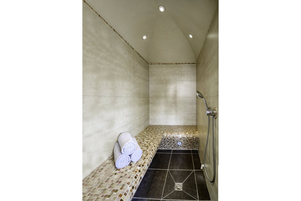 A bathroom with a toilet a towel rack and a shower