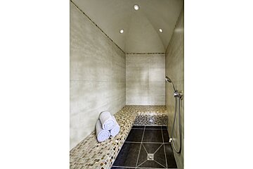 A bathroom with a toilet a towel rack and a shower