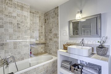 A bathroom with a bathtub and a sink with the word provence in the corner