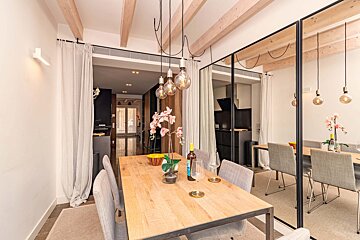 A dining room with a wooden table and chairs