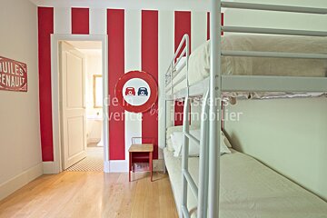 A bedroom with red and white stripes and bunk beds