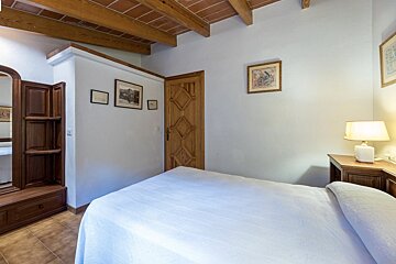 A bedroom with a bed a lamp and a mirror