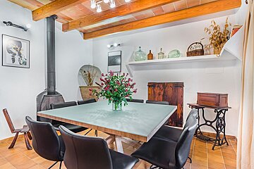A dining room table with a vase of flowers on it