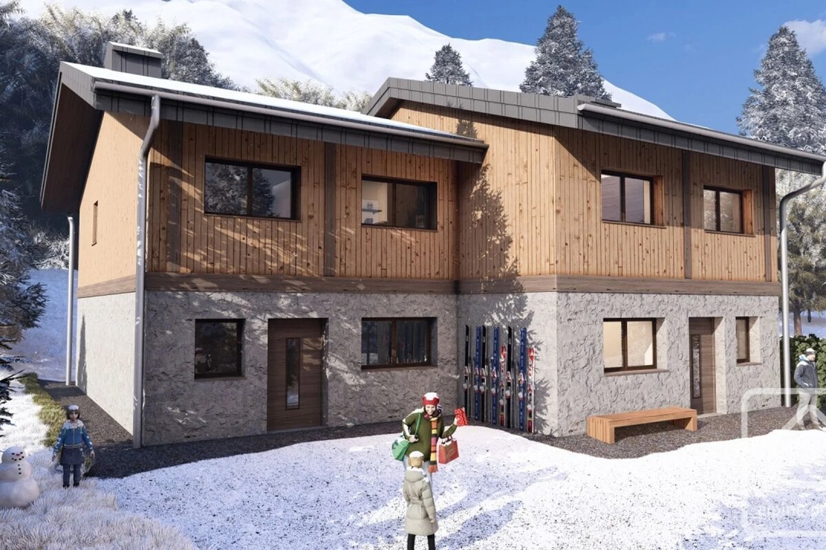 Modern two-story alpine chalet with a stone and wood facade, set in a snowy mountain landscape with people outside.