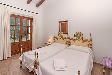 A bedroom with two beds and a mirror on the wall