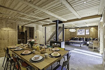 A dining room table with plates and bowls on it