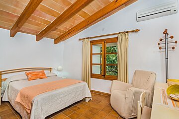 A bedroom with a king size bed and a chair