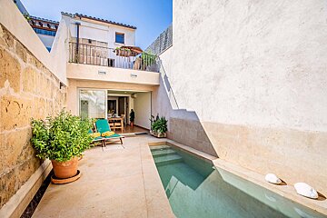 A small swimming pool in the backyard of a house