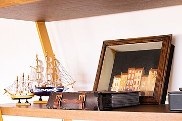 A shelf with a picture of buildings and a suitcase on it