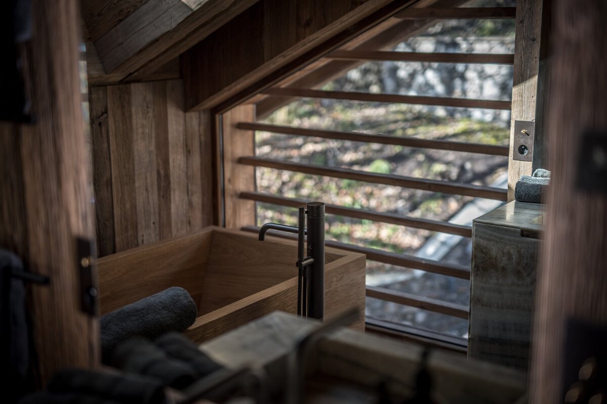 A bathroom with a wooden tub and a window