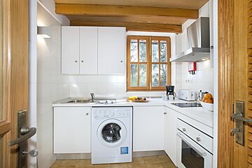 A kitchen with a washing machine and a stove