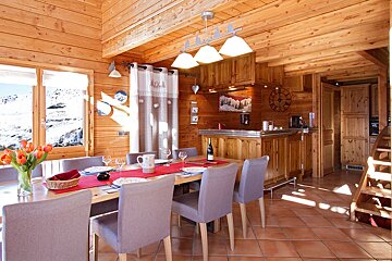 A dining room table with a bottle of wine on it