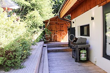 A wooden deck with a bbq and a sign that says en80