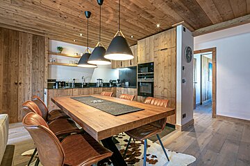 A dining room with a wooden table and chairs