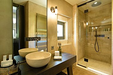 A bathroom with two sinks and a shower with provence by immobilier written on the wall