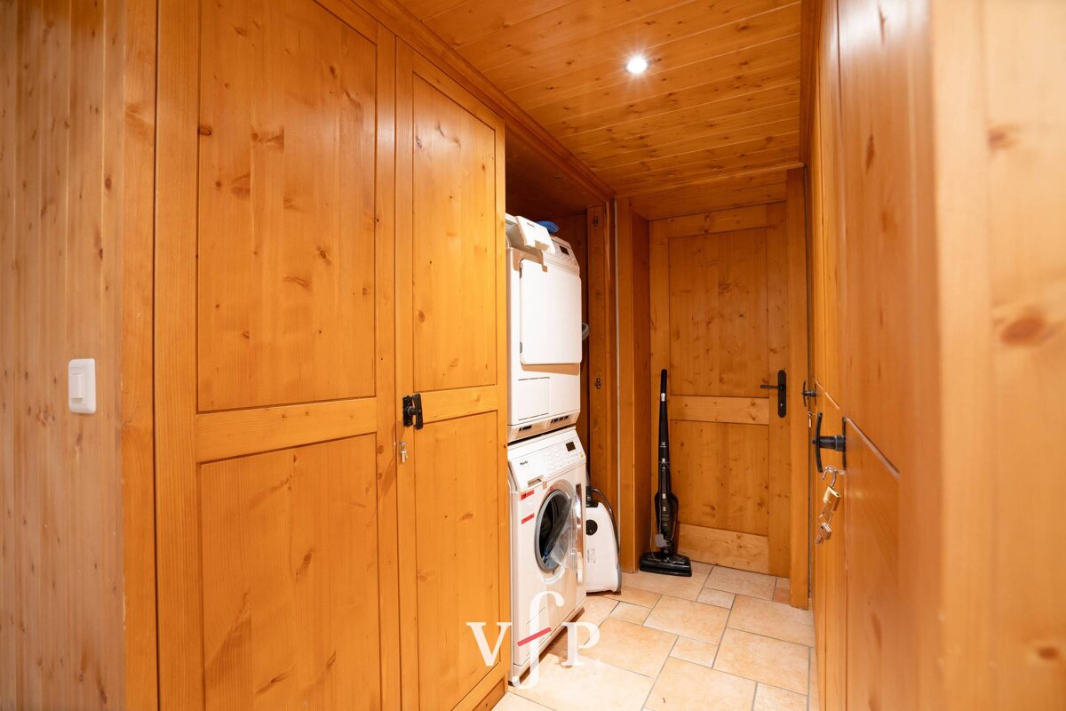 A washer and dryer are stacked on top of each other in a wooden room