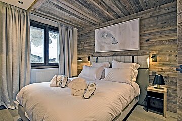 A bedroom with a picture of a polar bear on the wall above the bed