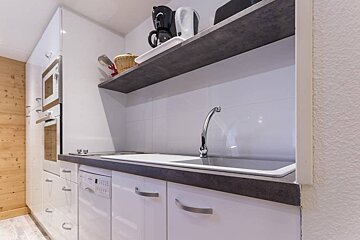A kitchen with white cabinets and a dishwasher that says ' bosch ' on it