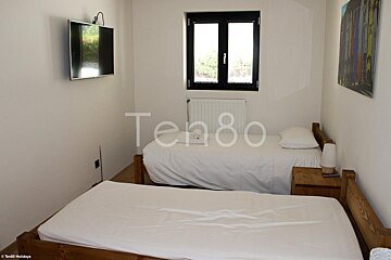 A bedroom with two beds and a television that says ten80