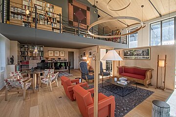 A living room with a red couch and chairs