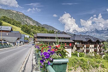 A row of houses on a hillside with mountains in the background