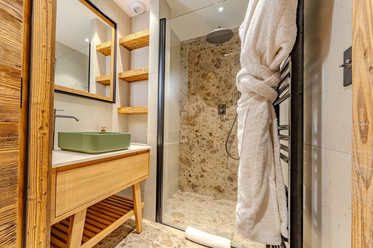 A bathroom with a green sink and a walk in shower