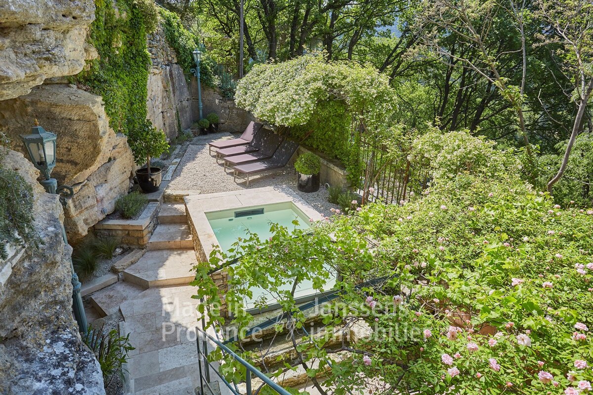 A swimming pool is surrounded by trees and a sign that says provence immobilier