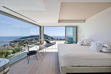 A bedroom with a large bed and a view of the ocean