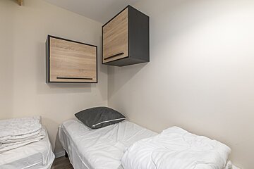 A small bedroom with a bed and two cabinets