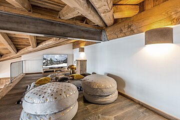 A wooden bedroom with a bed and a chair