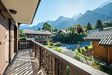 A balcony with a view of mountains and houses